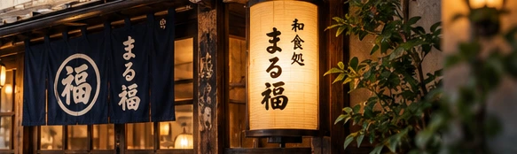 藍色の暖簾とまる福の看板を掲げた店舗外観イメージ